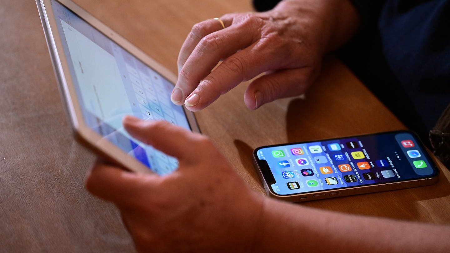 Eine Frau tippt auf einem iPad und iPhone