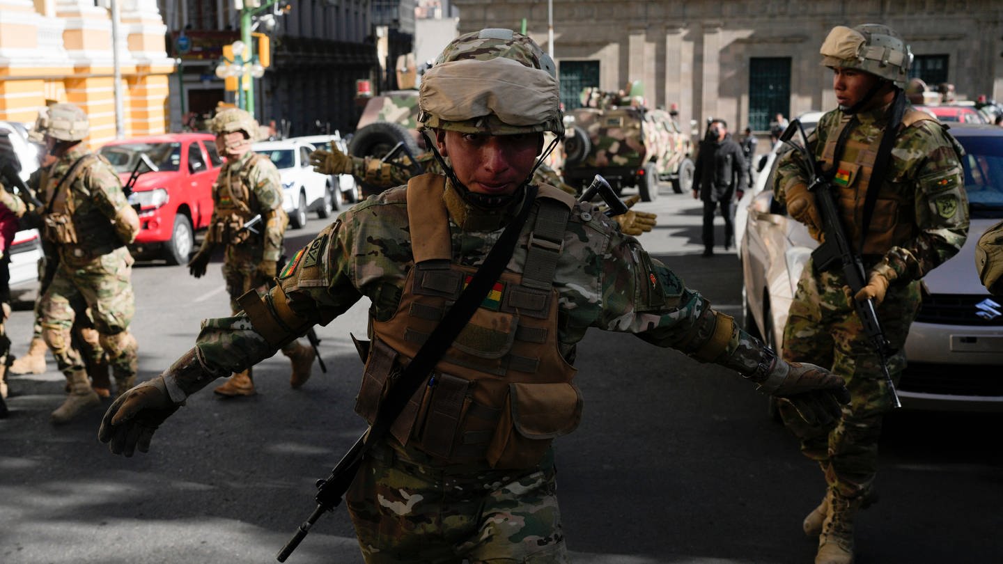 Ein Soldat fordert Journalisten auf, die Plaza Murillo zu verlassen, während sich Soldaten vor dem Präsidentenpalast auf der Plaza Murillo versammeln.