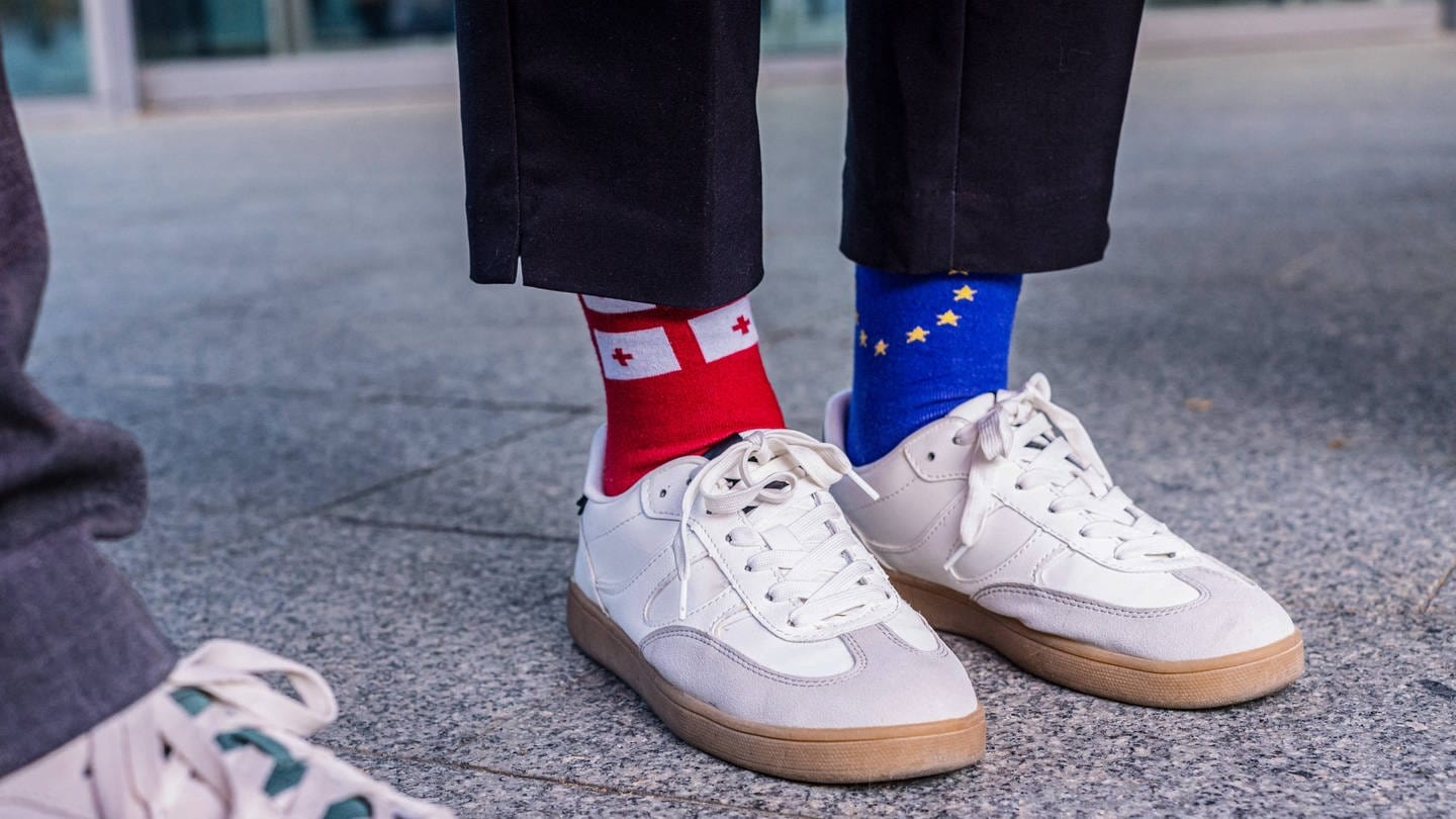 Eine Frau trägt Socken, mit den Flaggen der Europäischen Union EU und Georgien.
