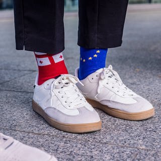 Eine Frau trägt Socken, mit den Flaggen der Europäischen Union EU und Georgien.