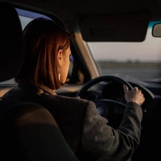 Eine junge Frau ist mit dem Auto unterwegs