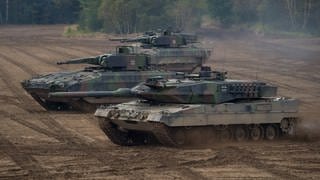 ARCHIV - Ein Kampfpanzer vom Typ "Leopard 2A6" sowie zwei Schützenpanzer vom Typ "Puma" bei der Vorbereitung zu einer Informationslehrübung in Niedersachsen
