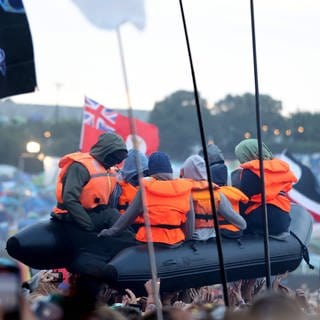 Während dem Glastonbury Festival "schwamm" ein Rettungsboot über der Crowd. Jetzt ist klar: Es ist ein Kunstwerk von Banksy.