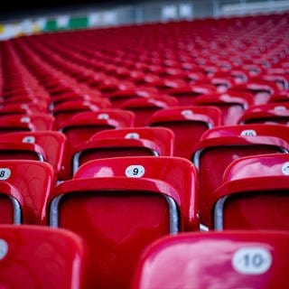Leere Sitze in roter Farbe symbolisieren die Forderung der Fans nach einem Verbot für Influencer auf normalen Sitplätzen in Stadien.