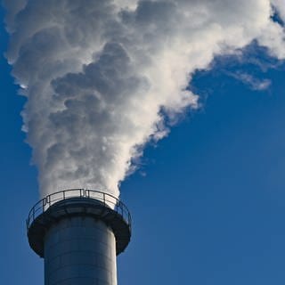 Symbolbild: Ein Schornstein einer Fabrik mit Dampf und Abgasen. In Baden-Württemberg war 2023 das Jahr mit dem niedrigsten CO2-Ausstoß seit 1990. 