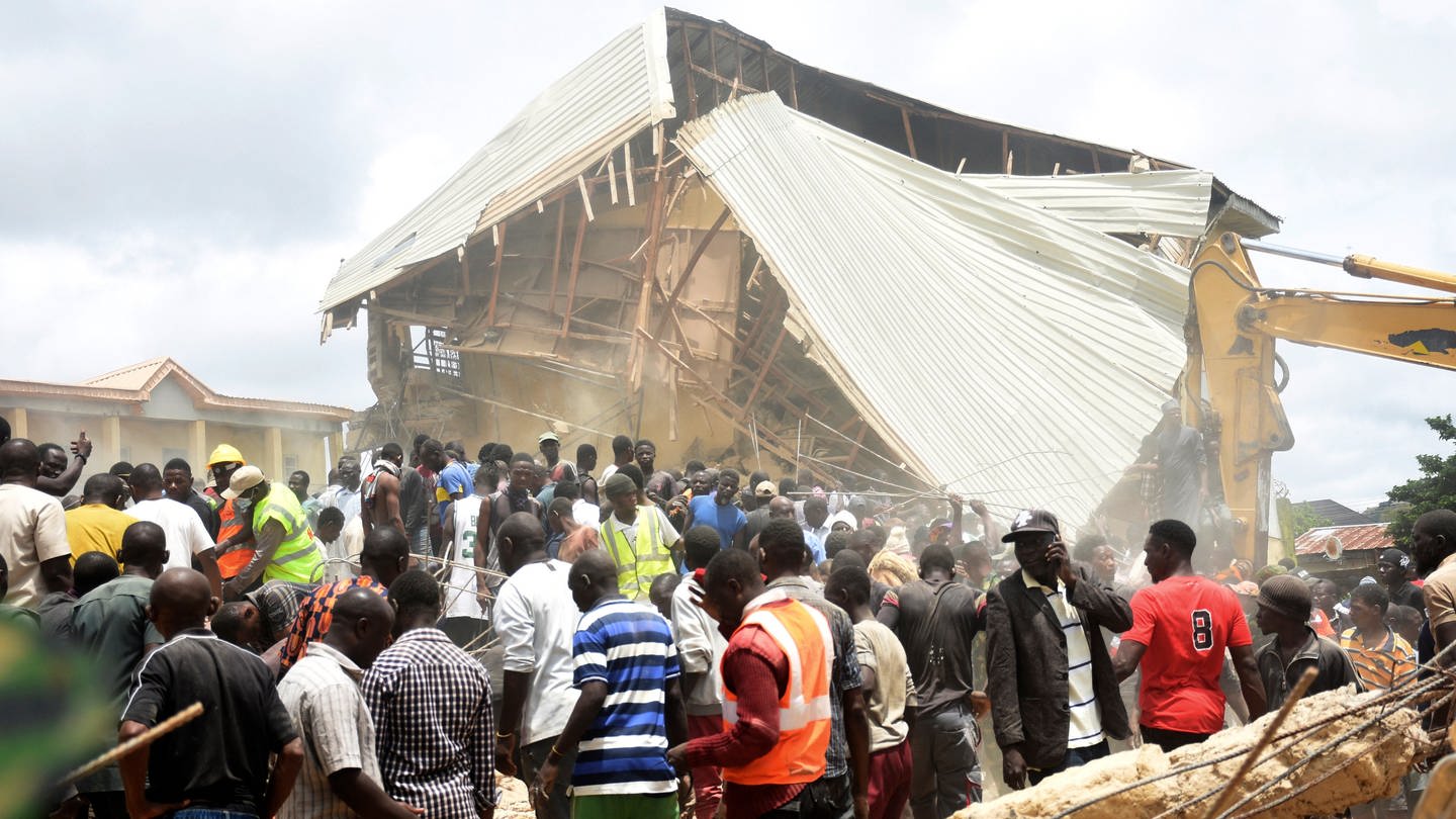 Menschen und Rettungskräfte versammeln sich am Ort eines eingestürzten zweistöckigen Gebäudes. Mehrere Schüler sind nach dem Einsturz eines Schulgebäudes im Norden Nigerias ums Leben gekommen, wie die Behörden mitteilten.