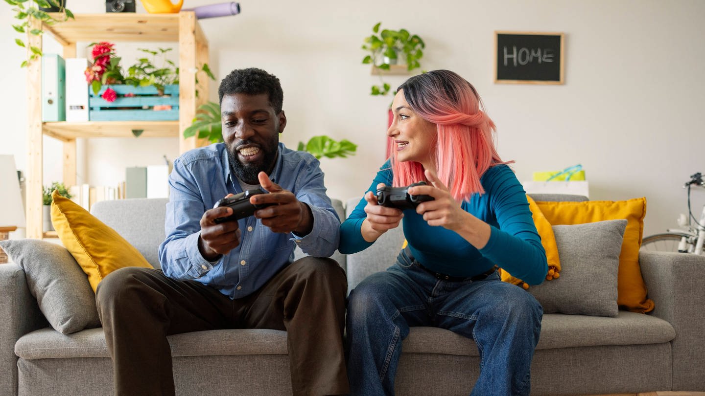 Zwei Freunde spielen gemeinsam Videospiele an der PlayStation