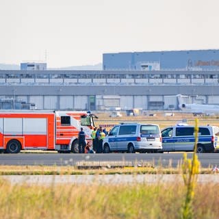 Einsatzfahrzeuge der Polizei stehen am Frankfurter Flughafen bei einer Aktion von Klimaaktivisten. Mehrere Demonstranten waren am frühen Morgen auf das Gelände des Flughafens eingedrungen und hatten sich festgeklebt. Der Flugverkehr ist vorläufig eingestellt worden, teilte ein Sprecher der Bundespolizei mit.
