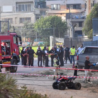 Israelische Polizisten und Feuerwehrleute arbeiten am Ort eines Raketenangriffs auf den israelisch kontrollierten Golanhöhen.