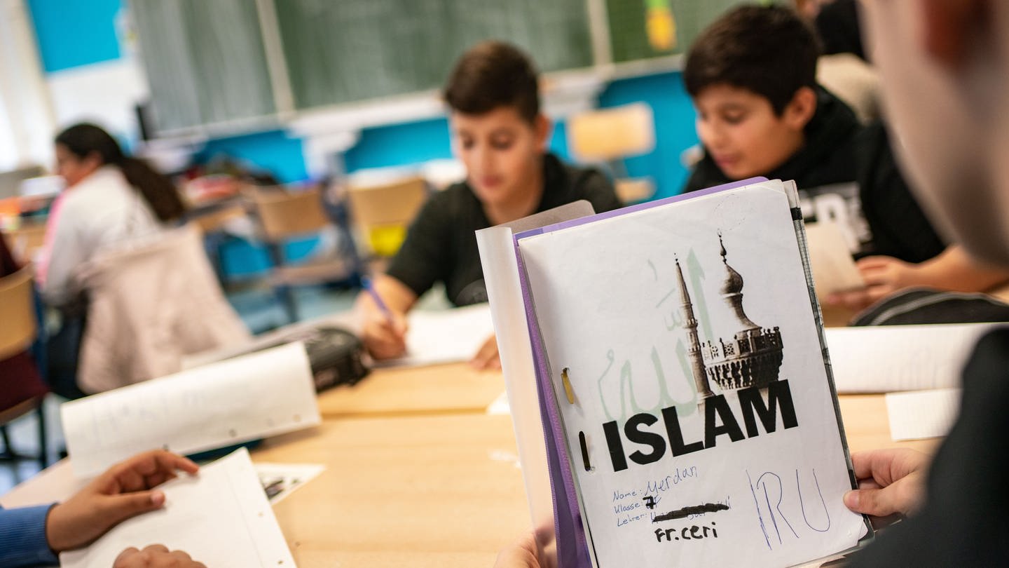 Ein Schüler öffnet seinen seinen selbst gestalteten Ordner beim Islamunterricht - in Baden-Württemberg soll er ausgebaut werden (Symbolbild)