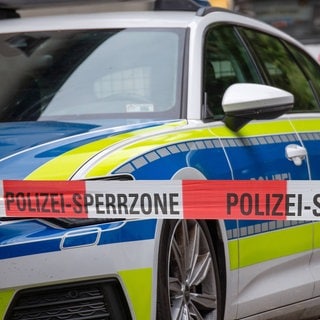 Symbolbild Polizeiabsperrung und Polizeiwagen