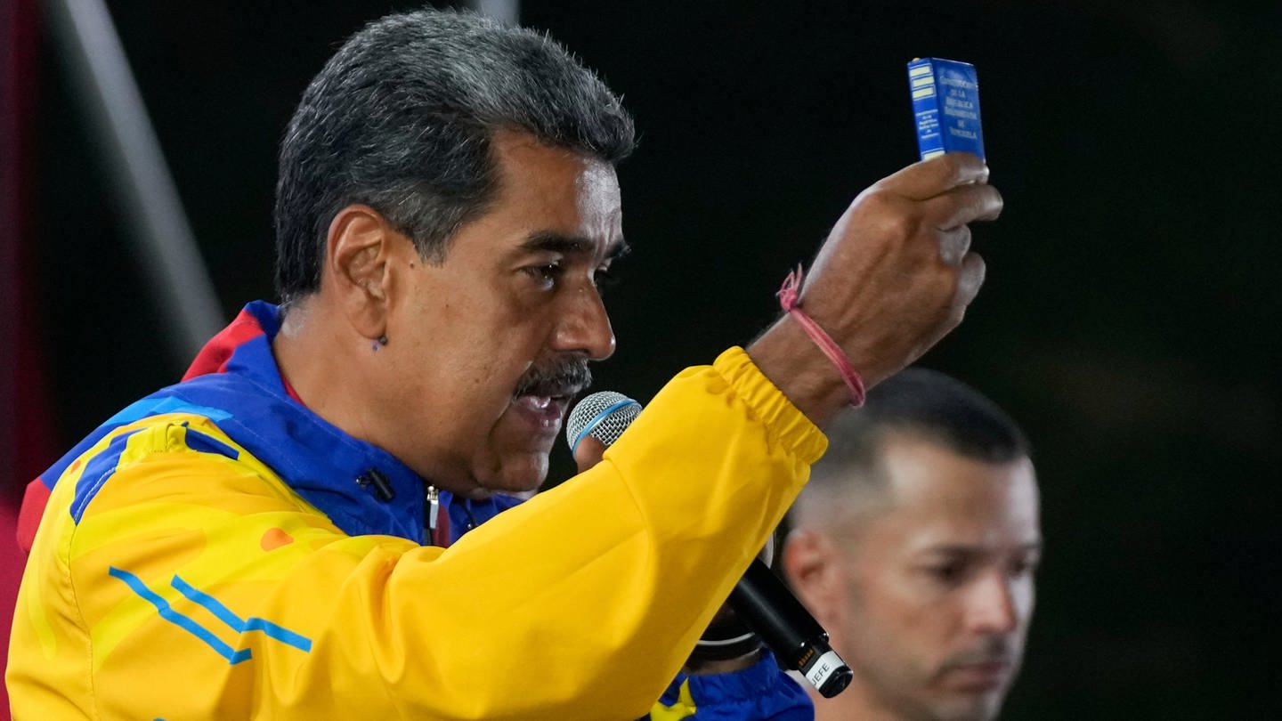 Nicolas Maduro, Präsident von Venezuela, zeigt eine Miniausgabe der venezolanischen Verfassung.