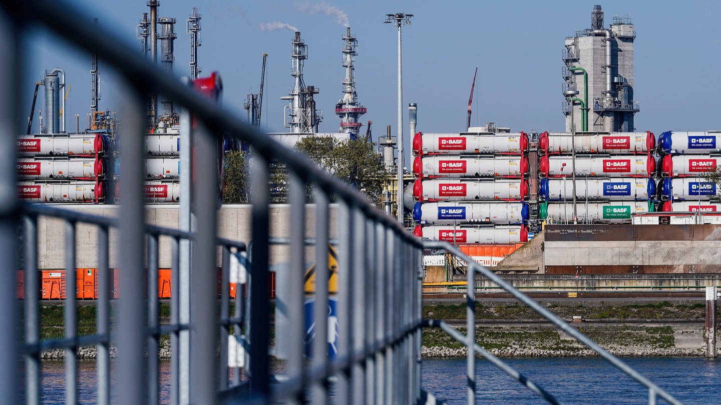 Hinter einem Hafensteg am Rhein stehen auf dem Werksgelände des Chemiekonzerns BASF