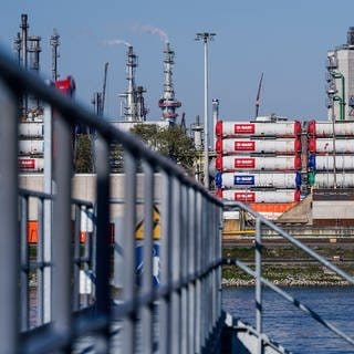 Hinter einem Hafensteg am Rhein stehen auf dem Werksgelände des Chemiekonzerns BASF 