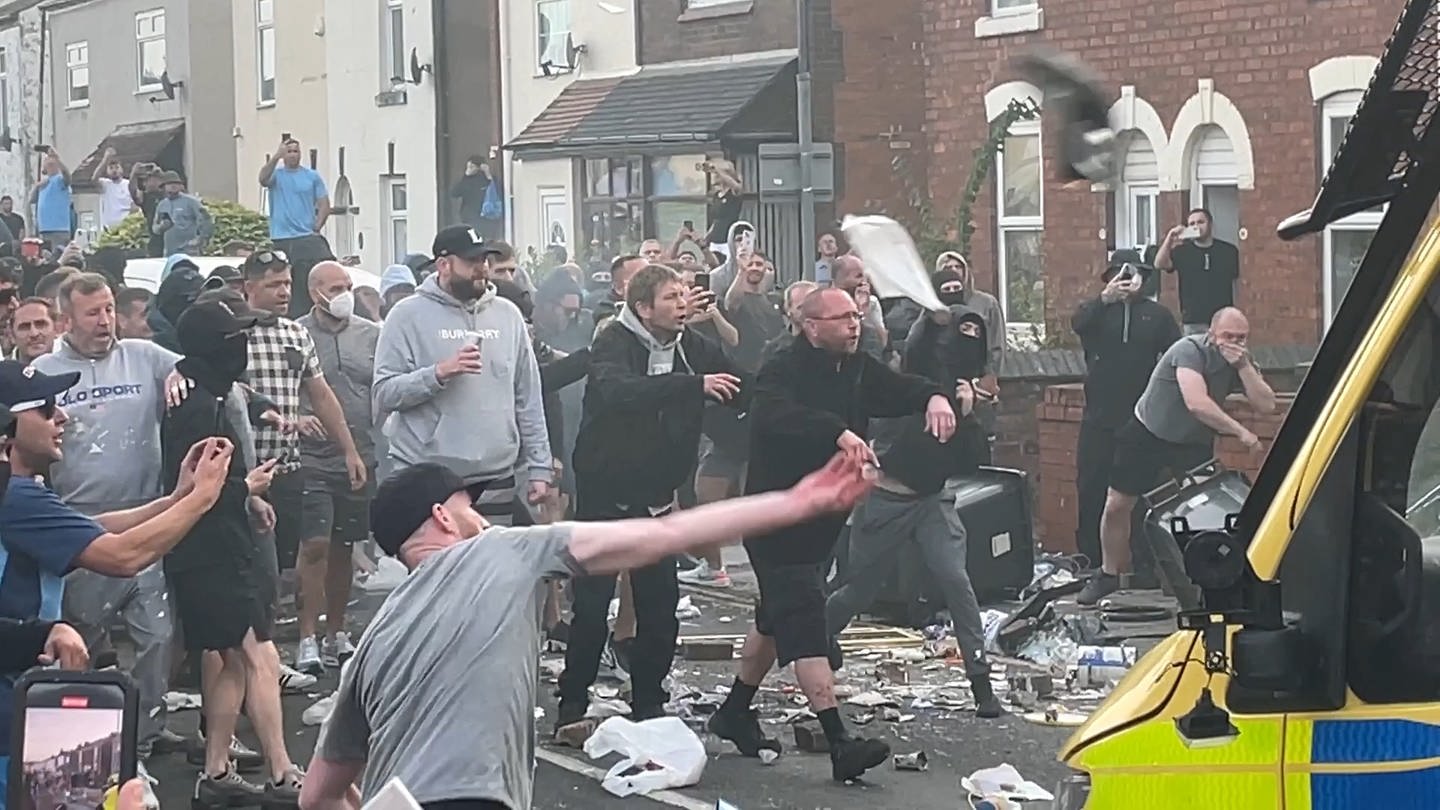 Menschen stoßen während Unruhen mit der Polizei zusammen, in der Nähe des Ortes, an dem am Vortag drei Mädchen bei einem Messerangriff getötet wurden.