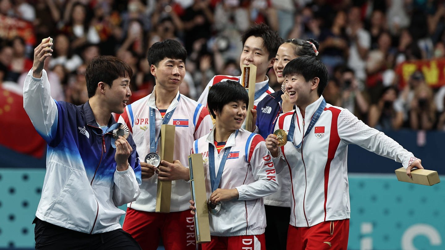 Die Goldmedaillengewinner Wang Chuqin/Sun Yingsha aus China, die Silbermedaillengewinner Ri Jong Sik/Kim Kum Yong aus der Demokratischen Volksrepublik Korea und die Bronzemedaillengewinner Lim Jonghoon/Shin Yubin aus Südkorea posieren für ein Selfie.