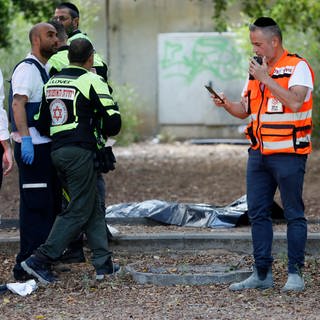 Ersthelfer arbeiten am Ort eines Messerangriffs. Ein Palästinenser aus dem israelischen besetzten Westjordanland hat in Israel zwei Menschen mit einem Messer getötet und zwei weitere verletzt.