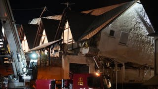 Ein Fahrzeug der Feuerwehr steht vor einem eingestürzten Hotel im Moselort Kröv im Landkreis Bernkastel-Wittlich (Rheinland-Pfalz)