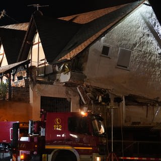 Ein Fahrzeug der Feuerwehr steht vor einem eingestürzten Hotel im Moselort Kröv im Landkreis Bernkastel-Wittlich (Rheinland-Pfalz)