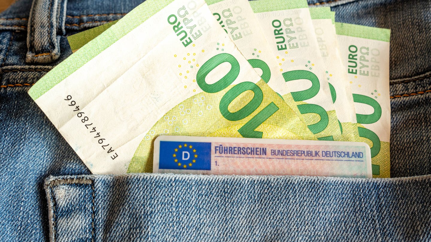 Hundert-Euro-Scheine und Führerschein in Jeans-Tasche.