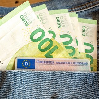 Hundert-Euro-Scheine und Führerschein in Jeans-Tasche.