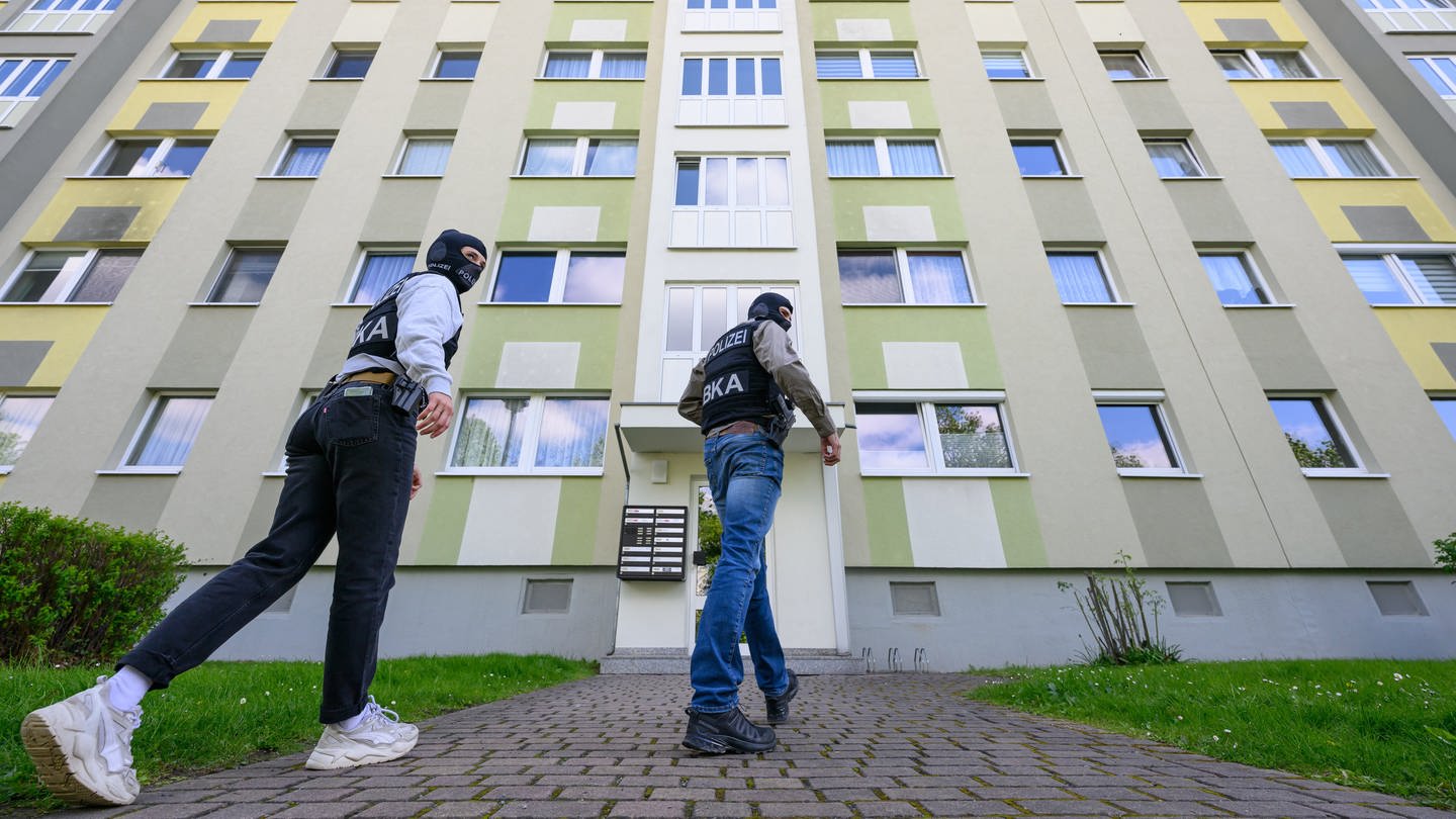 Polizisten vom Bundeskriminalamt (BKA) gehen zu einer Durchsuchung in ein Mehrfamilienhaus.