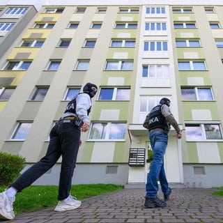 Polizisten vom Bundeskriminalamt (BKA) gehen zu einer Durchsuchung in ein Mehrfamilienhaus. 