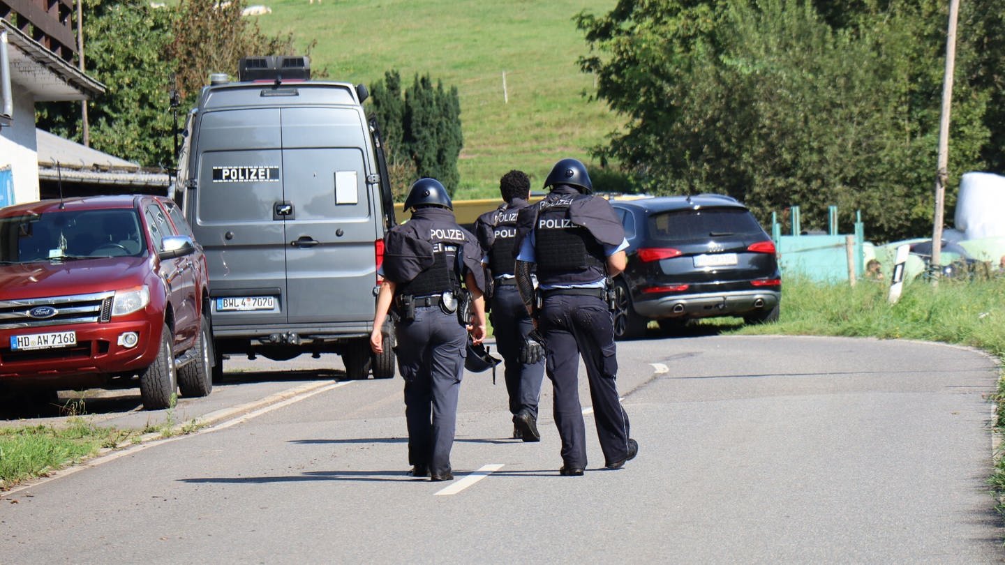 Polizisten in Schutzwesten im Ortsteil Bärsbach: In Heiligkreuzsteinach im Rhein-Neckar-Kreis sollen bei einem Einsatz Schüsse auf die Polizei abgegeben worden sein.