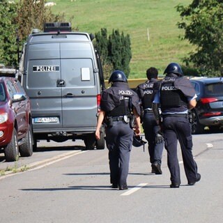 Polizisten in Schutzwesten im Ortsteil Bärsbach: In Heiligkreuzsteinach im Rhein-Neckar-Kreis sollen bei einem Einsatz Schüsse auf die Polizei abgegeben worden sein.