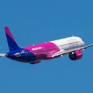 Ein Flugzeug Airbus A321neo der Airline Wizz Air fliegt im Himmel.