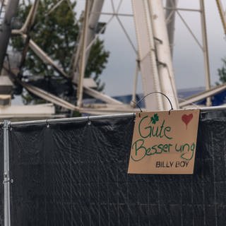 Besucher haben nach dem Brand "Gute Besserung"-Schild am Riesenrad auf dem Highfield-Festival angebrahct.