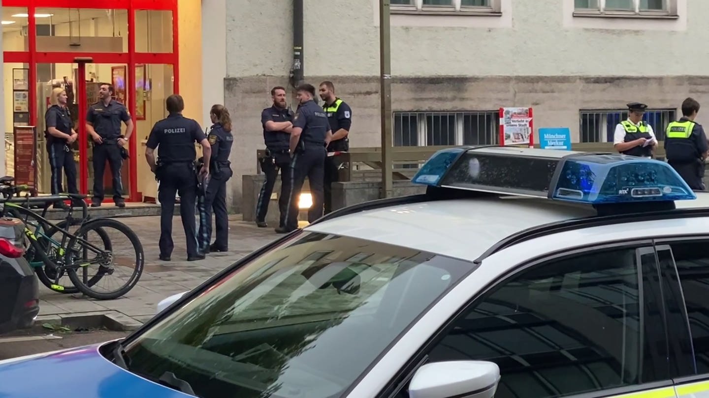 Einsatzkräfte der Polizei stehen vor einem Supermarkt im Münchner Stadtteil Sendling. In einem Supermarkt in München ist am Abend eine Frau von der Polizei erschossen worden, nachdem sie die Einsatzkräfte mit dem Messer attackiert haben soll.