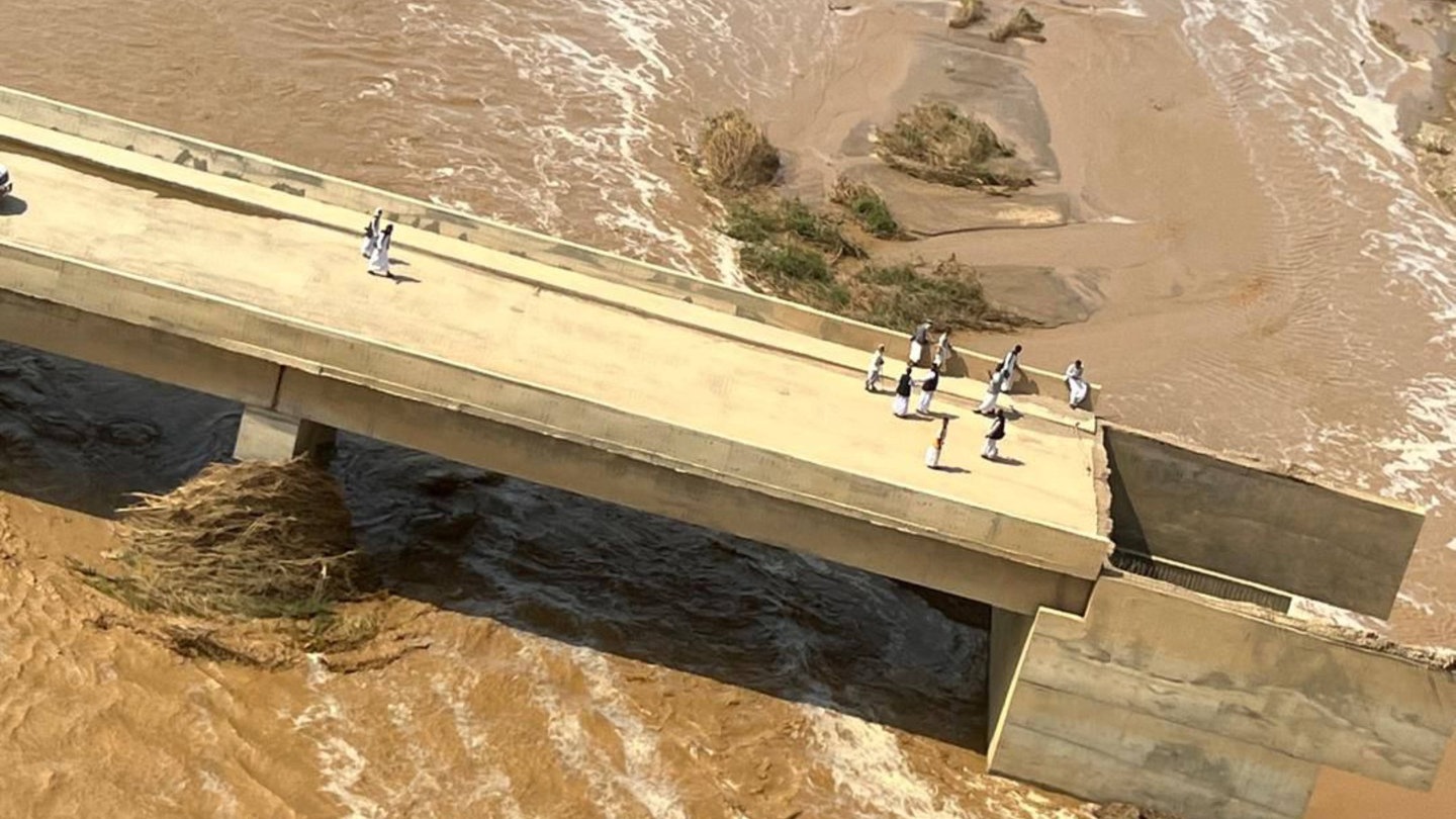 Der Arbaat-Staudamm im Sudan ist nach heftigen Regenfällen gebrochen. Menschen stehen auf dem kaputten Damm.