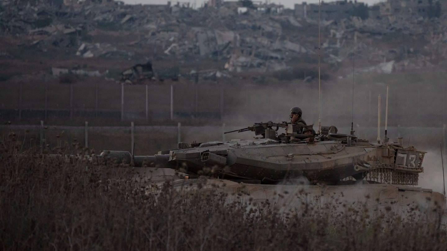 Israelische Soldaten bewegen sich auf einem Panzer nahe der Grenze zwischen Israel und dem Gazastreifen, gesehen vom Süden Israels aus.