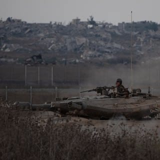 Israelische Soldaten bewegen sich auf einem Panzer nahe der Grenze zwischen Israel und dem Gazastreifen, gesehen vom Süden Israels aus.