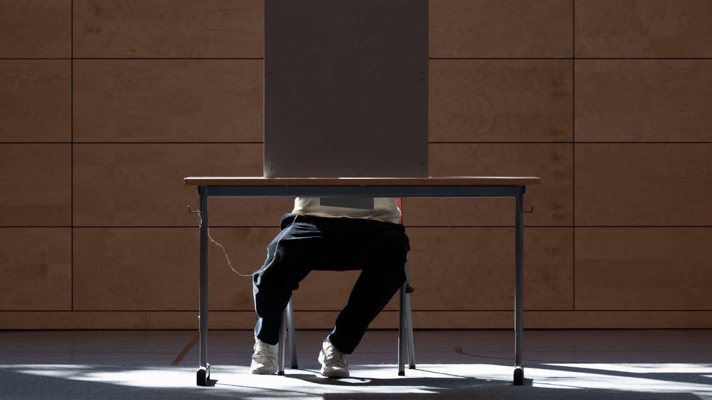 Ein Wähler sitzt für die Landtagswahl in Sachsen in einer Sporthalle in einer Wahlkabine. Auch in Thüringen wurde gewählt.