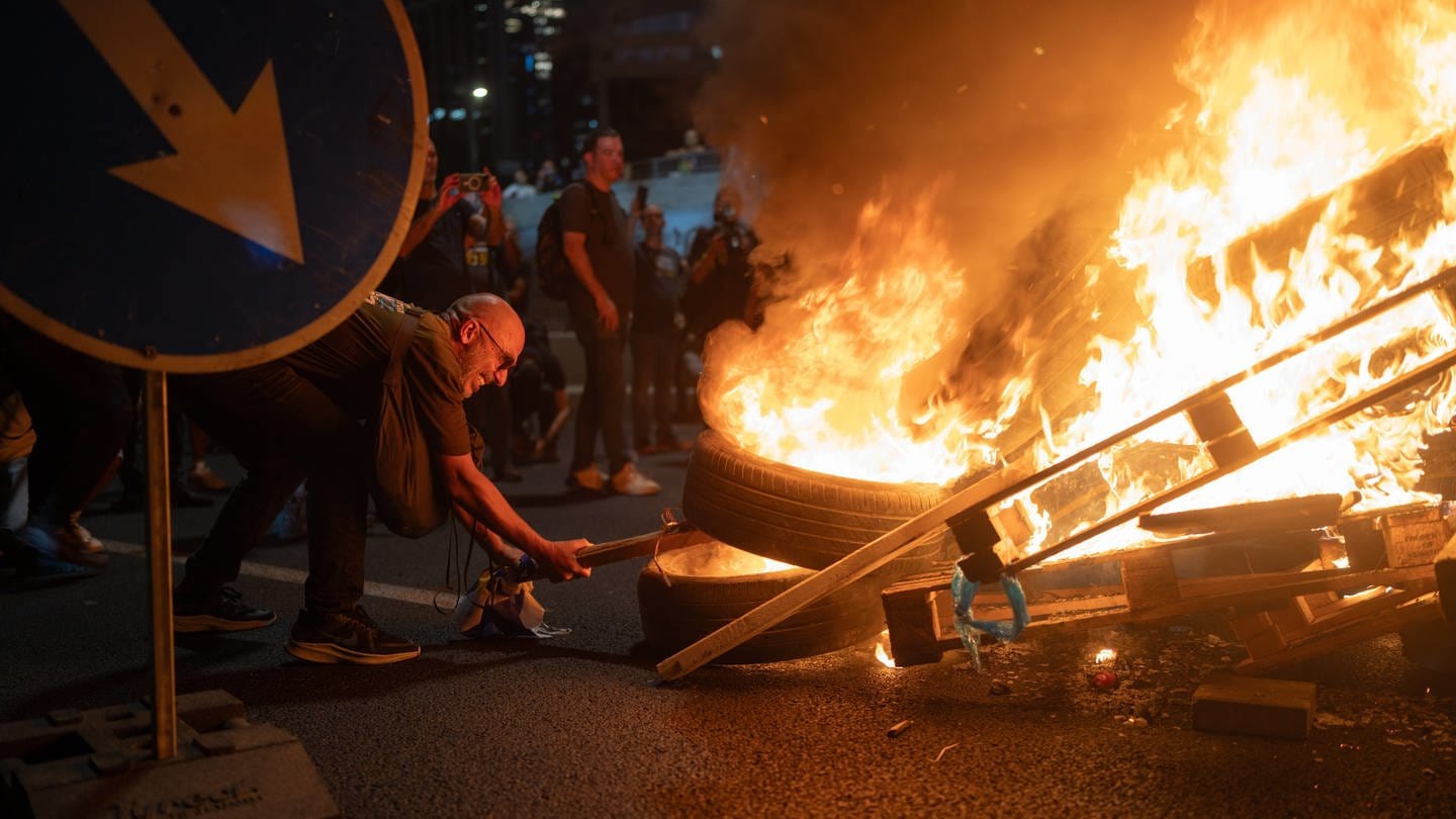 Menschen verbrennen Gegenstände bei einer der größten Protestaktionen der letzten Jahre, nachdem die israelische Armee die Leichen von sechs Geiseln im Gazastreifen geborgen hat.