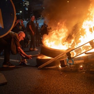 Menschen verbrennen Gegenstände bei einer der größten Protestaktionen der letzten Jahre, nachdem die israelische Armee die Leichen von sechs Geiseln im Gazastreifen geborgen hat.