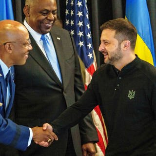 Charles Q. Brown Jr. (l), Generalstabschef der Streitkräfte der USA, und Wolodymyr Selenskyj (r), Präsident der Ukraine, begrüßen sich beim Treffen der Ukraine-Kontaktgruppe auf der US Air Base Ramstein.