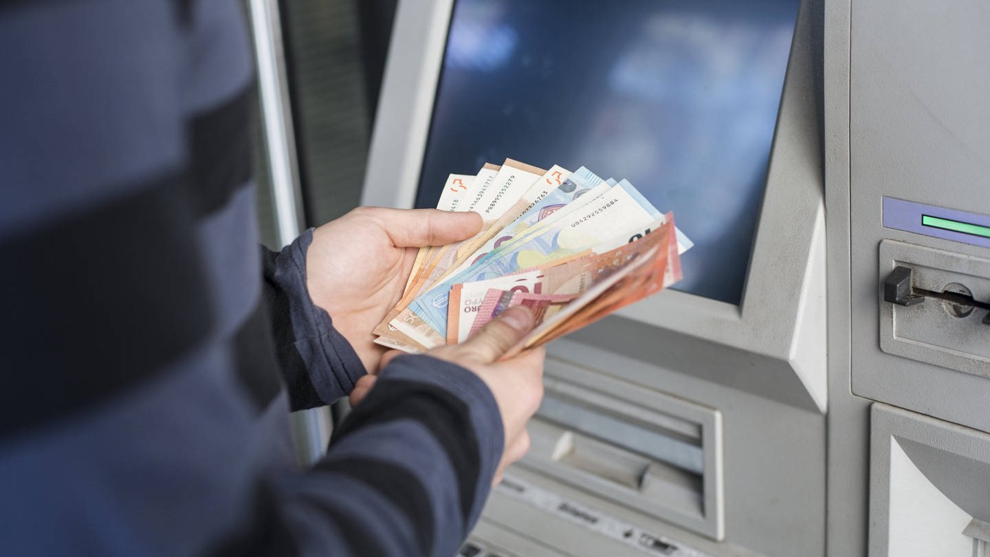 Geldscheine zählen am Bankautomat.