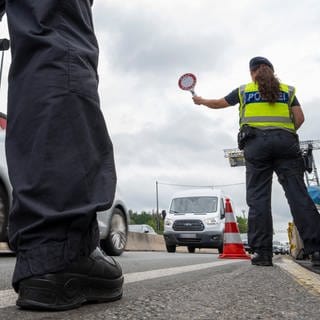 Polizisten stehen  bei Grenzkontrolle der Bundespolizei am Grenzübergang zwischen Österreich und Deutschland an der Autobahn A8. 