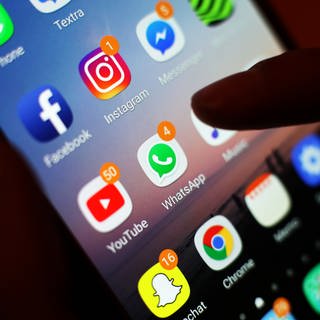 Ein Blick auf ein Handy mit den verschiedenen Social Media Apps, wie Facebook, Instagram, WhatsApp. Australien will für Social Media eine Altersgrenze von 14 bis 16 Jahren.