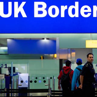 Grenzbeamte stehen am Flughafen Heathrow unter einem Schild mit der Aufschrift «UK Border».