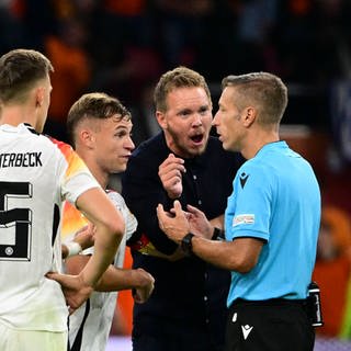 Joshua Kimmich und Julian Nagelsmann diskutieren mit dem Schiedsrichter nach dem Schlusspfiff.