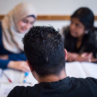 Drei Schüler nehmen am 16.05.2017 in einer Volkshochschule in Berlin an einem Integrationskurs teil.