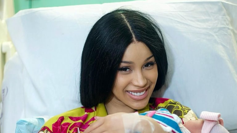 Cardi B liegt mit ihre dritten Kind in einem Krankenhaus-Bett und lächelt in die Kamera.