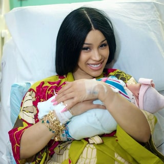 Cardi B liegt mit ihre dritten Kind in einem Krankenhaus-Bett und lächelt in die Kamera.