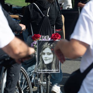 Ein Bild von Mahsa Amini bei einer Fahrrad-Demo in Köln an ihrem zweiten Todestag.