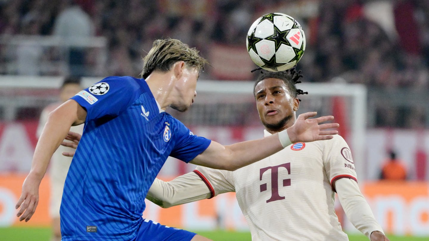 Fußball, Champions League, FC Bayern München - Dinamo Zagreb, Vorrunde, Spieltag 1, Allianz Arena, Münchens Michael Olise (r) und Zagrebs Takuya Ogiwara kämpfen um den Ball.