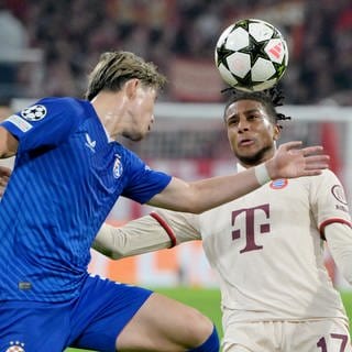 Fußball, Champions League, FC Bayern München - Dinamo Zagreb, Vorrunde, Spieltag 1, Allianz Arena, Münchens Michael Olise (r) und Zagrebs Takuya Ogiwara kämpfen um den Ball.